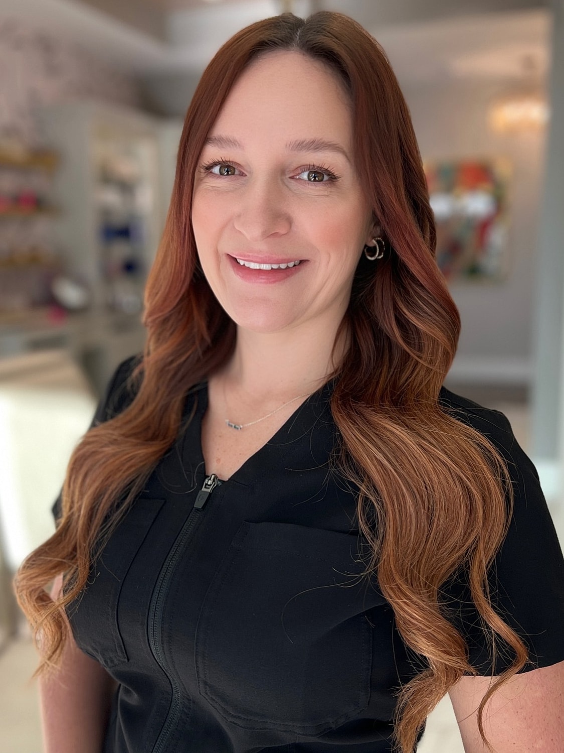 Smiling woman with long hair in professional attire.