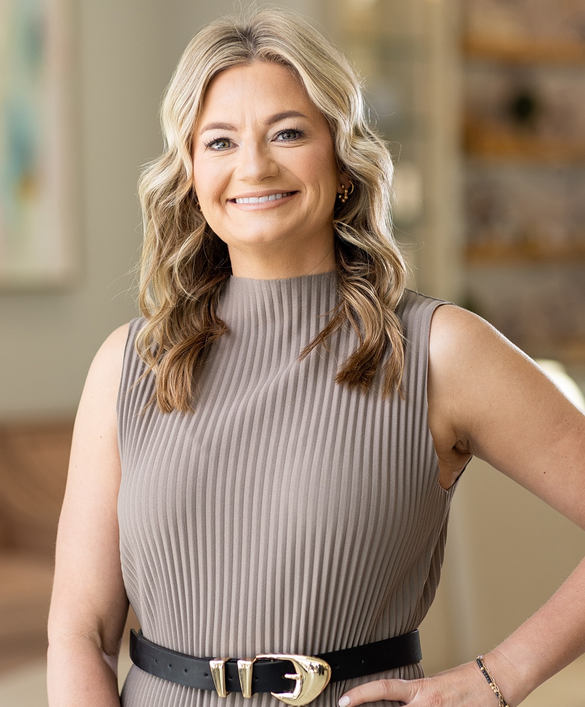 Woman in black scrubs, smiling in hallway.