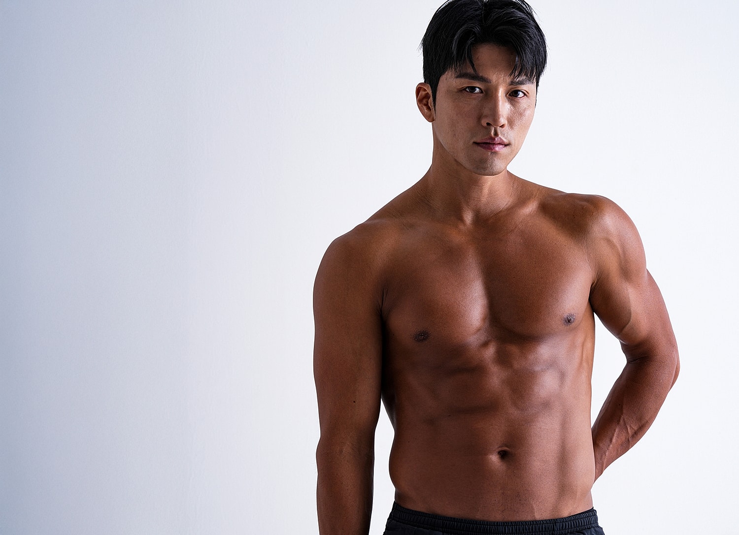 Shirtless man posing against a plain background.