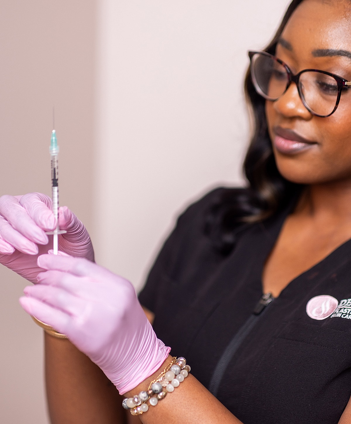 Healthcare professional preparing a syringe for injection.