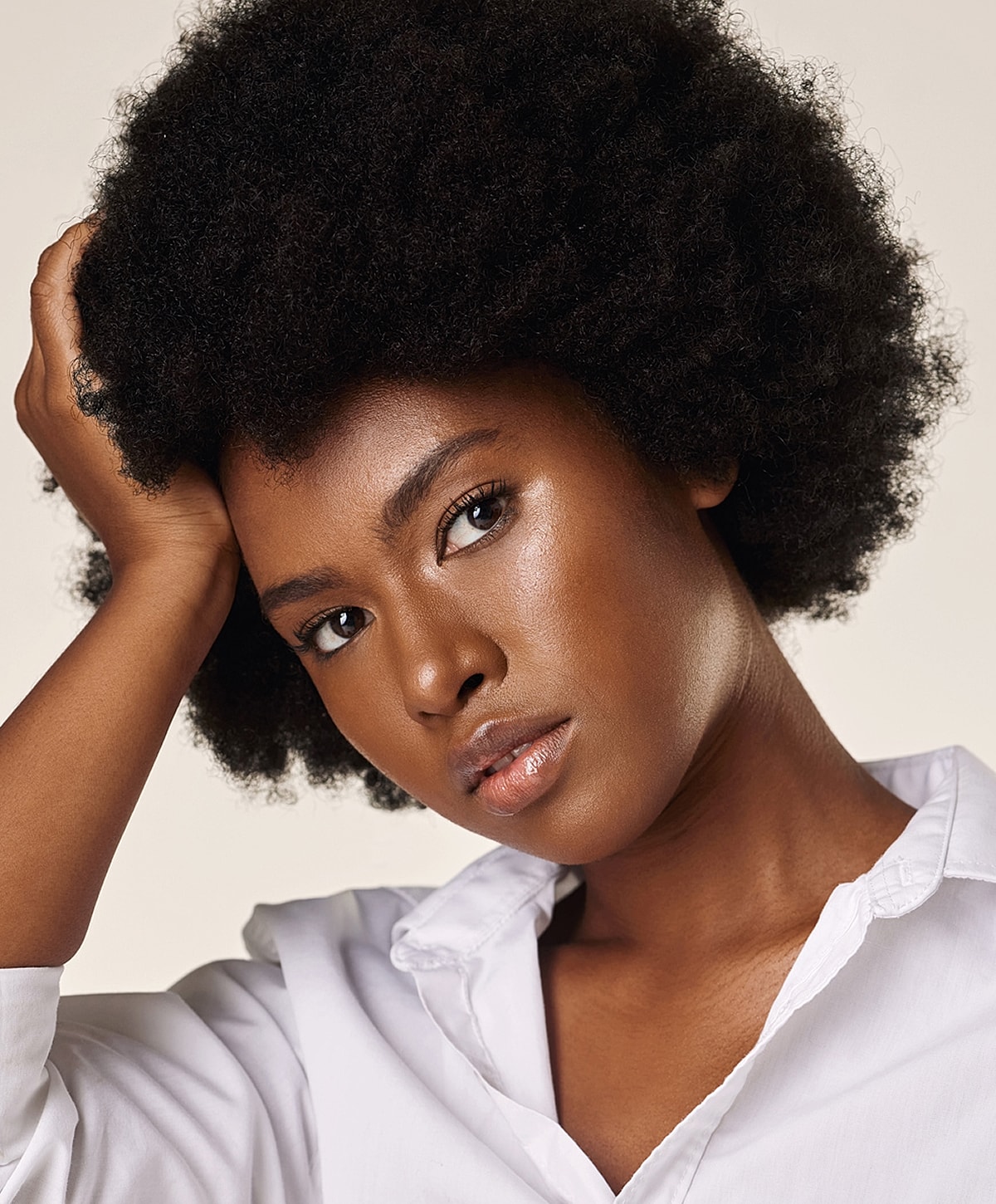 Woman with curly hair smiling joyfully.