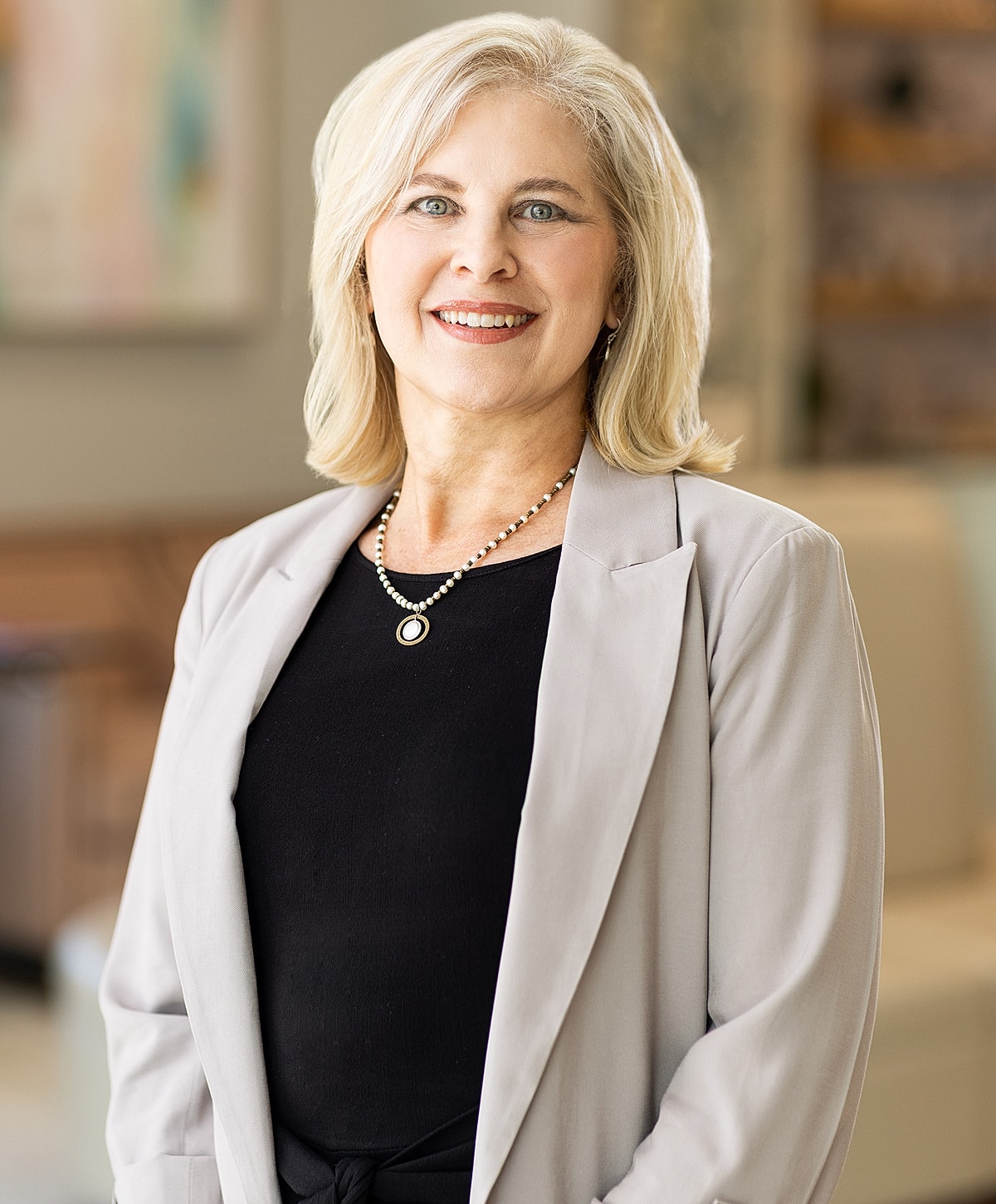 Smiling woman in medical uniform, indoors setting.