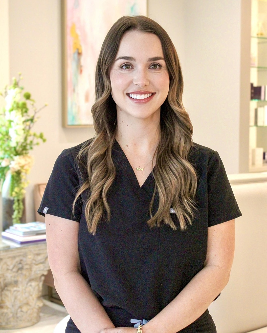 Smiling professional in black scrubs, indoors.