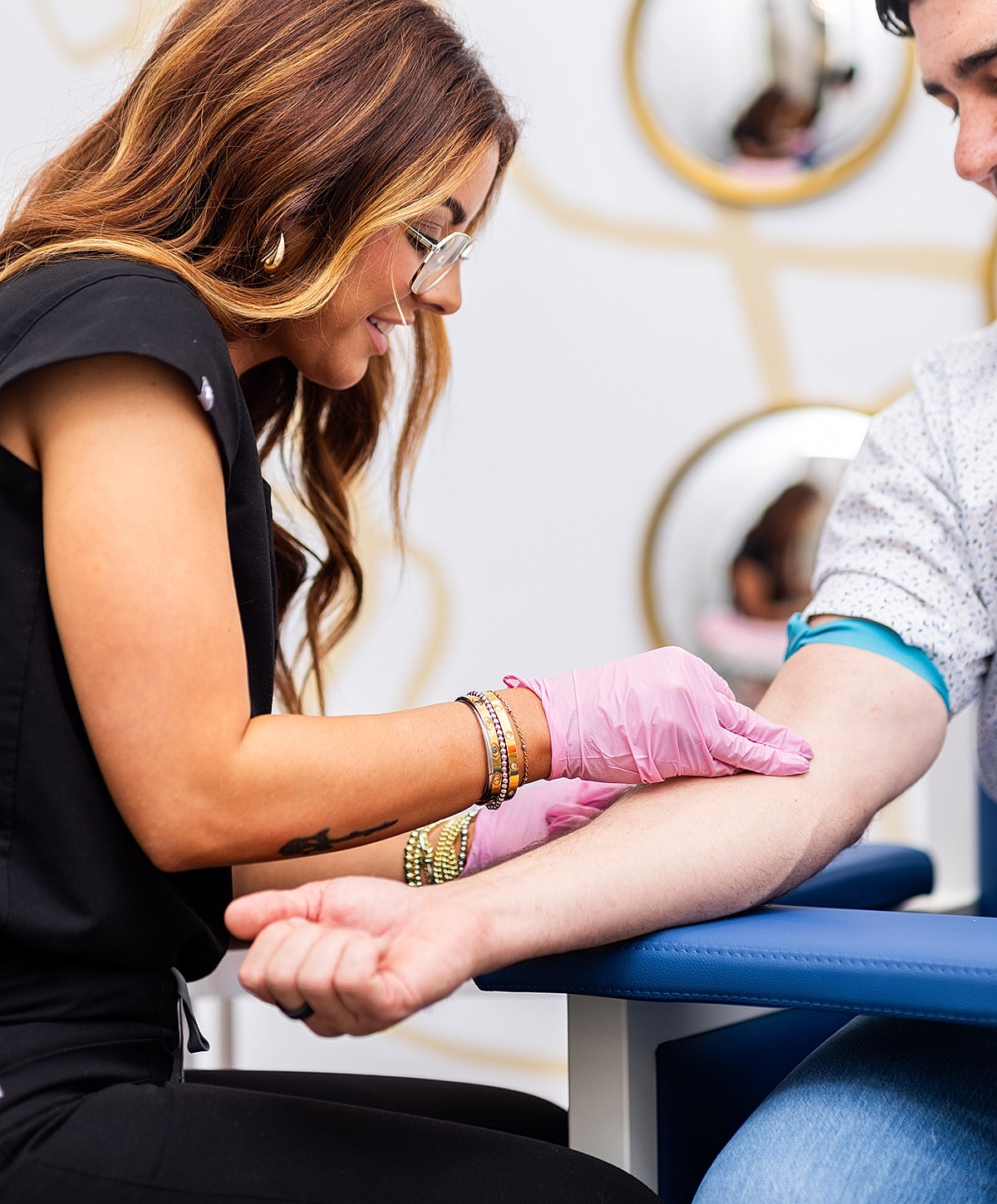 Nurse assisting patient with arm procedure.