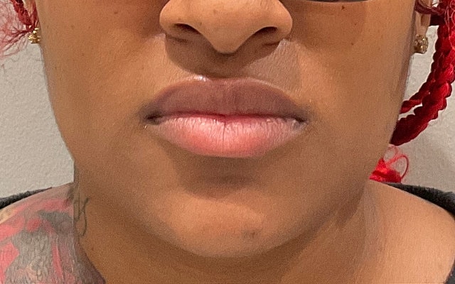 Close-up of lips and chin with tattoos.
