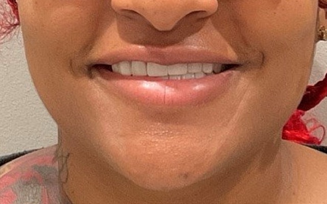 Smiling person with red hair and tattoos
